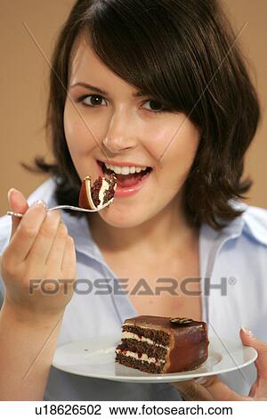 Young woman eating slice of chocolate cake, portrait, close up View Large Photo Image Stock Image - Young woman eating slice of chocolate cake, portrait, close up. Fotosearch