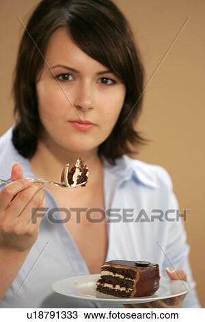 Young woman eating slice of chocolate cake, portrait, close up View Large Photo Image Stock Image - Young woman eating slice of chocolate cake, portrait, close up. Fotosearch