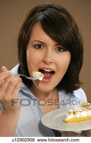 Young woman eating slice of fruit pie, portrait, close up View Large Photo Image Stock Photo - Young woman eating slice of fruit pie, portrait, close up. Fotosearch