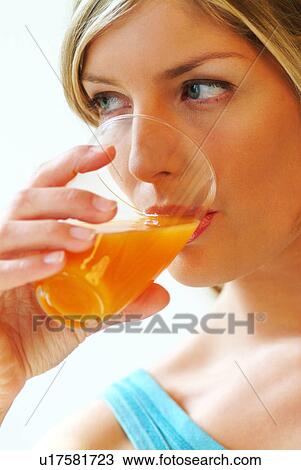 Close-up of woman drinking orange juice View Large Photo Image Stock Image - Close-up of woman drinking orange juice. Fotosearch