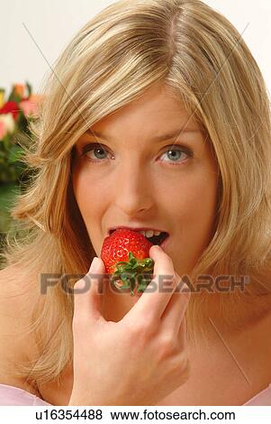 Stock Photo - Portrait of Woman eating strawberry. Fotosearch