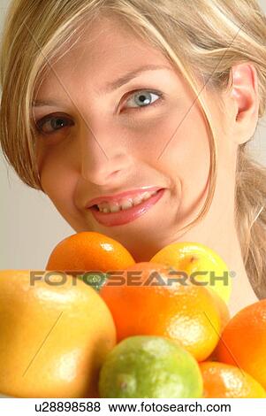 Stock Photo - Portrait of Woman with bowl of citrus fruit. Fotosearch
