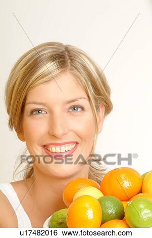 Stock Photograph - Portrait of Woman with bowl of citrus fruit. Fotosearch