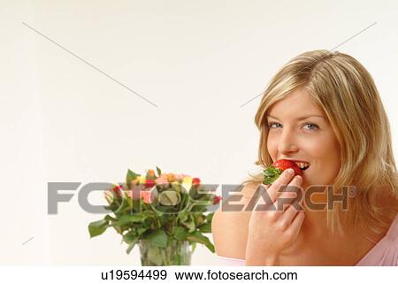 Stock Photo - Woman eating strawberry. Fotosearch