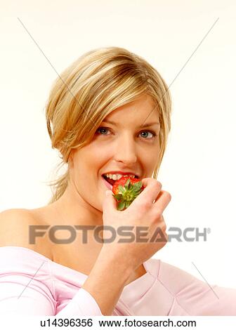 Stock Photograph - Woman eating strawberry. Fotosearch