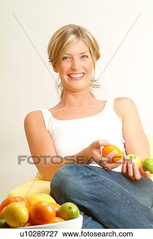 Woman holding citrus fruit, fruit bowl in foreground View Large Photo Image Stock Photo - Woman holding citrus fruit, fruit bowl in foreground. Fotosearch