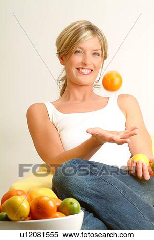 Stock Photography - Woman tossing orange. Fotosearch