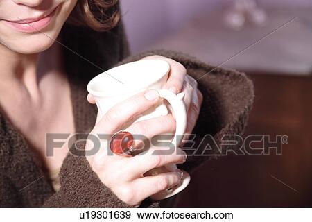Stock Photo - Young woman holding cup of tea, close up. Fotosearch