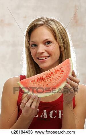 Young woman with long blond hair eating a slice of watermelon, portrait View Large Photo Image Stock Image - Young woman with long blond hair eating a slice of watermelon, portrait. Fotosearch