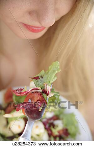 Woman eating salad, close up View Large Photo Image Stock Image - Woman eating salad, close up. Fotosearch