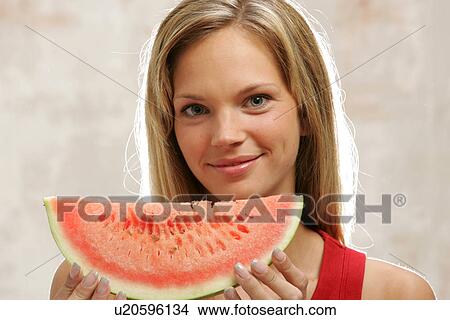 Young woman with long blond hair eating a slice of watermelon, portrait View Large Photo Image Picture - Young woman with long blond hair eating a slice of watermelon, portrait. Fotosearch