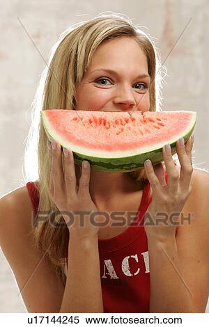 Young woman with long blond hair eating a slice of watermelon, portrait View Large Photo Image Stock Photography - Young woman with long blond hair eating a slice of watermelon, portrait. Fotosearch