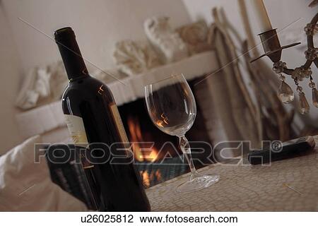 Bottle and glass of wine on a table in front of the fireplace, stillife View Large Photo Image Stock Image - Bottle and glass of wine on a table in front of the fireplace, stillife. Fotosearch