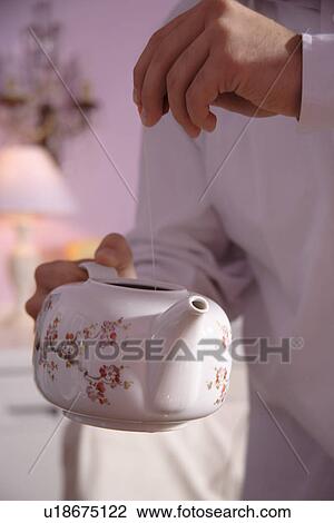 Man taking tea bags out of old fashioned teapot, close up View Large Photo Image Stock Image - Man taking tea bags out of old fashioned teapot, close up. Fotosearch