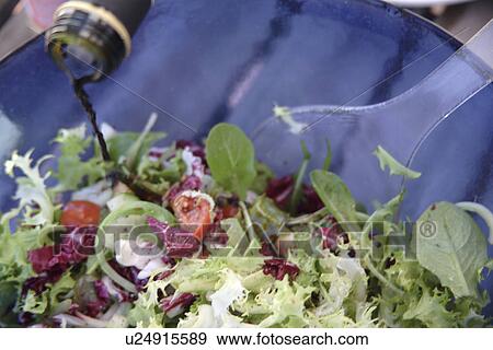 Stock Photo - Preparing fresh salad: adding vinegar. Fotosearch