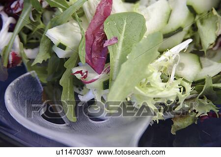 Stock Photo - Preparing fresh salad: mixing everything, close up. Fotosearch