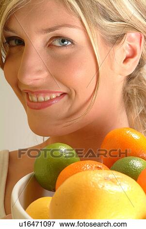 Stock Photo - Portrait of Woman with bowl of citrus fruit. Fotosearch
