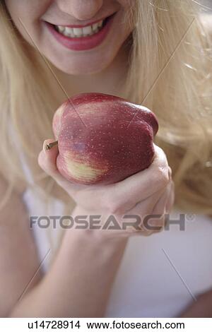 Picture - Woman eating apple, close up. Fotosearch