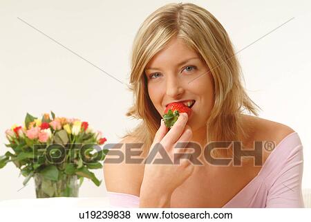 Stock Photo - Woman eating strawberry. Fotosearch