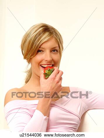 Stock Photograph - Woman eating strawberry. Fotosearch