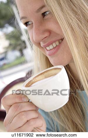 Young blond woman drinking cappuccino in a cafe, side view View Large Photo Image Stock Image - Young blond woman drinking cappuccino in a cafe, side view. Fotosearch