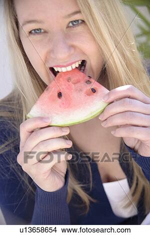 Young blond woman eating a slice of watermelon, portrait View Large Photo Image Picture - Young blond woman eating a slice of watermelon, portrait. Fotosearch