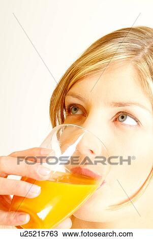 Stock Image - Close-up of woman drinking orange juice. Fotosearch