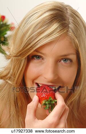 Stock Photo - Portrait of Woman eating strawberry. Fotosearch
