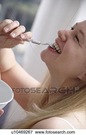 Young blond woman eating bowl of cereals, laughing, close up View Large Photo Image Stock Photo - Young blond woman eating bowl of cereals, laughing, close up. Fotosearch