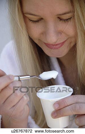 Young blond woman eating pure yogurt, close up View Large Photo Image Stock Image - Young blond woman eating pure yogurt, close up. Fotosearch