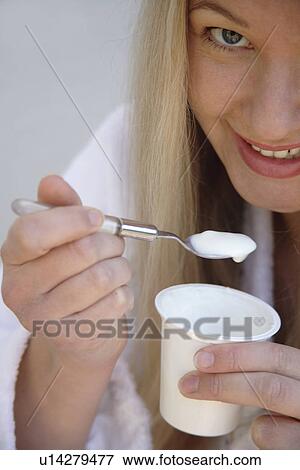 Young blond woman eating pure yogurt, close up View Large Photo Image Stock Photo - Young blond woman eating pure yogurt, close up. Fotosearch