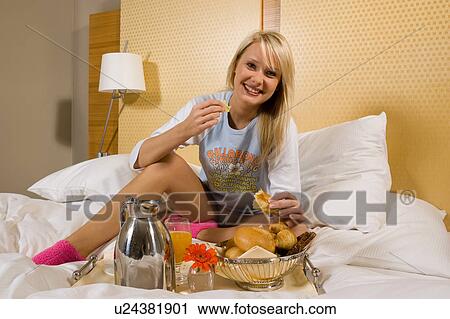 Young girl having breakfast in bed in her pajamas View Large Photo Image Stock Image - Young girl having breakfast in bed in her pajamas. Fotosearch