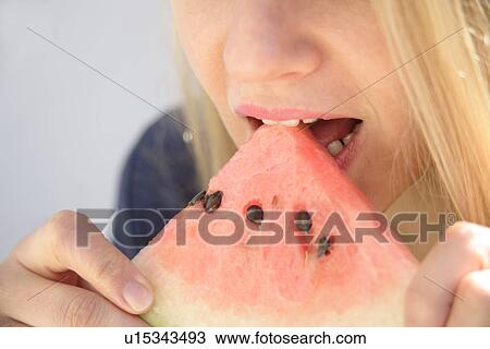 Young woman eating watermelon, close up View Large Photo Image Stock Image - Young woman eating watermelon, close up. Fotosearch