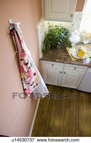 Stock Photo - Aprons hanging on a kitchen wall, high angle. Fotosearch