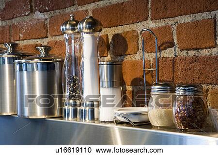 Stock Image - Detail of cooking spices on stainless steel shelf. Fotosearch