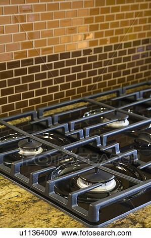 Stock Photo - Gas Stovetop and Brick Tiles. Fotosearch