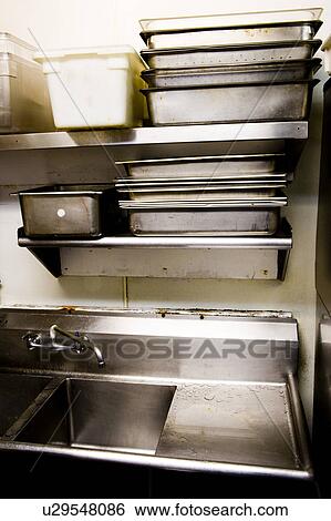 Stock Photograph - Large Stainless Steel Sink with Overhead Shelving. Fotosearch