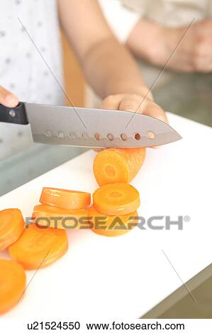 Hand cutting a carrot View Large Photo Image Stock Image - Hand cutting a carrot. Fotosearch
