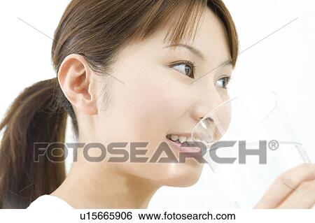 Woman drinking a glass of water View Large Photo Image Stock Photograph - Woman drinking a glass of water. Fotosearch