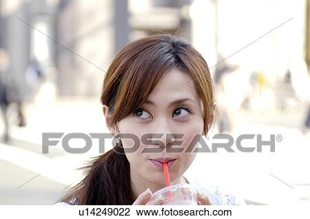 Stock Image - Woman who drinks juice. Fotosearch