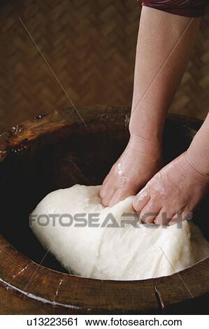 Stock Image - A woman making rice cake. Fotosearch