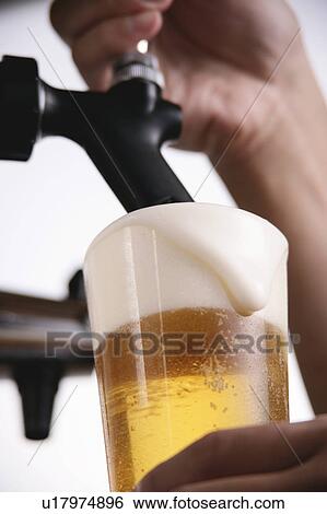 Stock Photograph - A man pouring beer into glass. Fotosearch