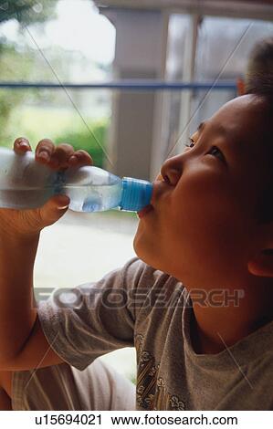 Stock Image - Boy drinking bottle of soda. Fotosearch