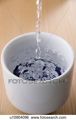 Stock Photograph - Sake pouring into cup. Fotosearch
