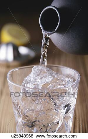 Stock Photo - Shochu pouring into glass. Fotosearch