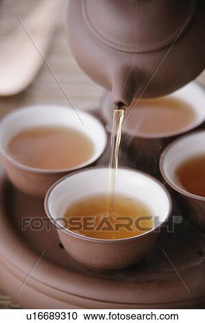Tea pouring into tea cup View Large Photo Image Stock Image - Tea pouring into tea cup. Fotosearch