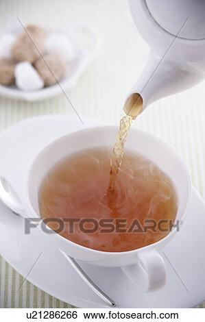Stock Photograph - Tea pouring into tea cup. Fotosearch