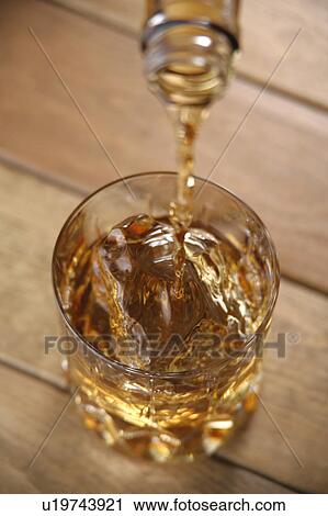 Stock Image - Whiskey pouring into glass. Fotosearch