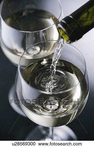 Stock Image - White wine pouring into glass. Fotosearch