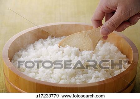 A woman scooping steamed rice View Large Photo Image Stock Photo - A woman scooping steamed rice. Fotosearch